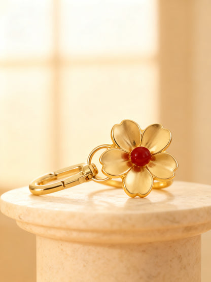 Fleur bag charm macro blossom detail with clasp on marble