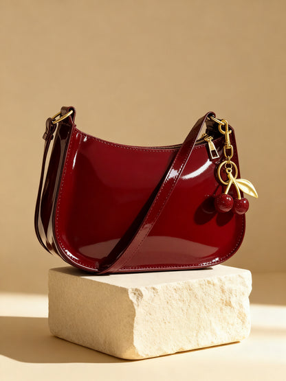 Cherry red glossy patent shoulder bag Cherry Charm Bag with golden cherry charm on stone pedestal