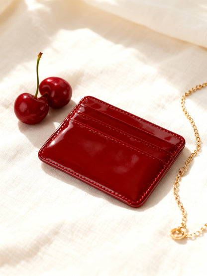 Griotte cardholder cherry red glossy patent flat lay with cherries