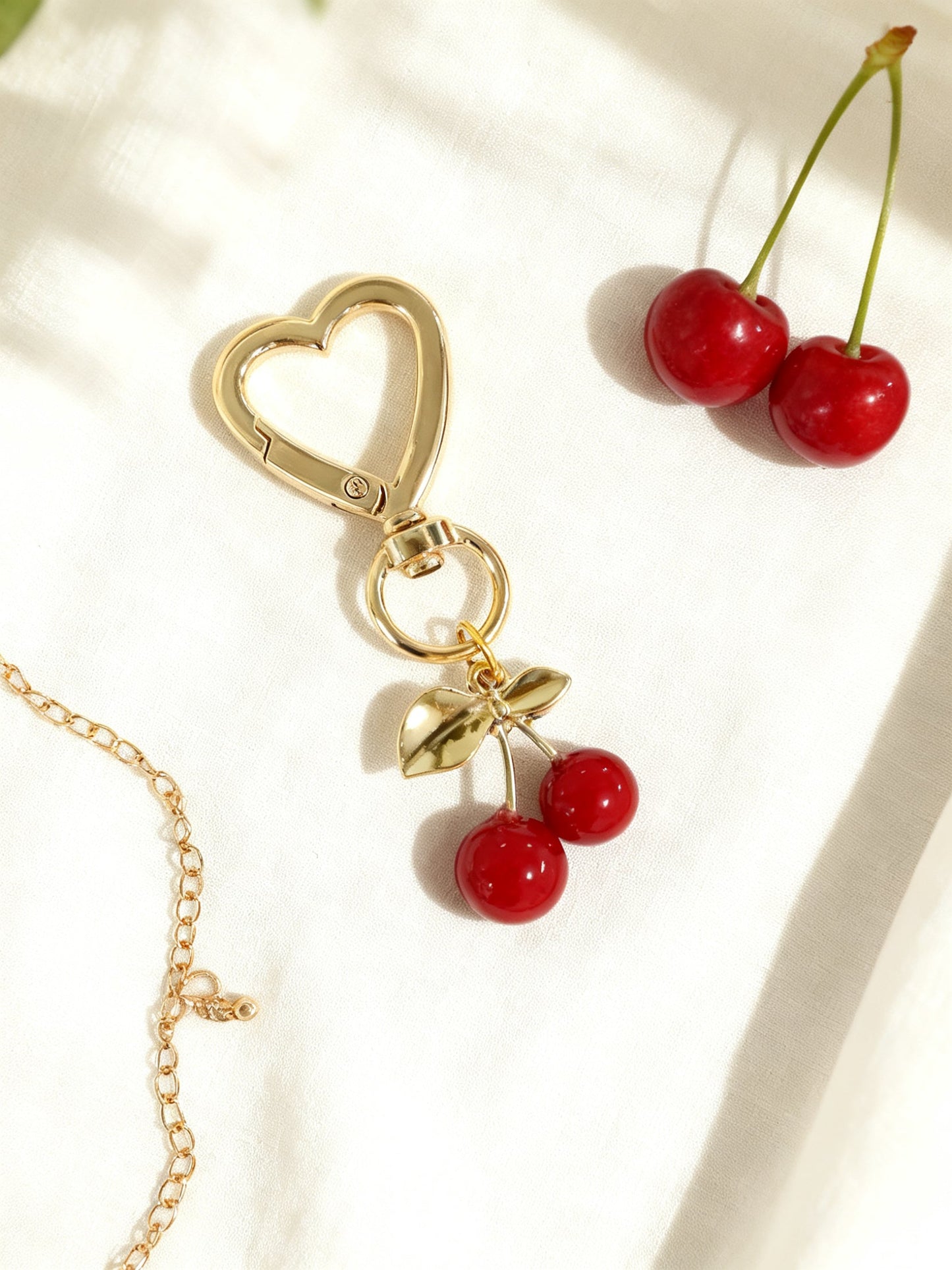 Fleur bag charm flat lay with cherries